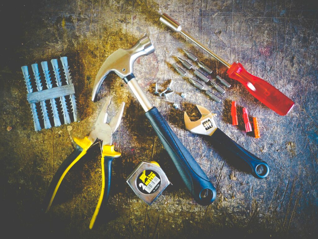 pexels-photo-175039-175039 Collection of hand tools including hammer, screwdriver, and pliers in a workshop setting.